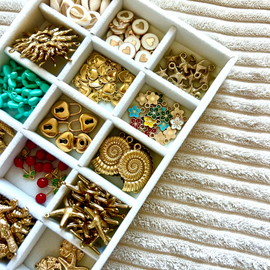 Bar à charms avec perles et pendentifs pour créer un bijou personnalisé lors d’un atelier créatif