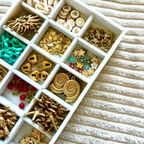 Bar à charms avec perles et pendentifs pour créer un bijou personnalisé lors d’un atelier créatif