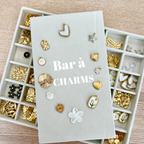 Bar à charms avec perles et pendentifs pour créer un bijou personnalisé lors d’un atelier créatif